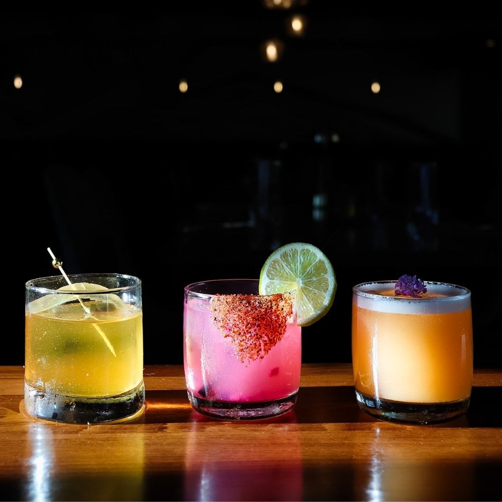 Colorful craft cocktails and wine at Slowly, served during happy hour with shared bites in Pacific Beach