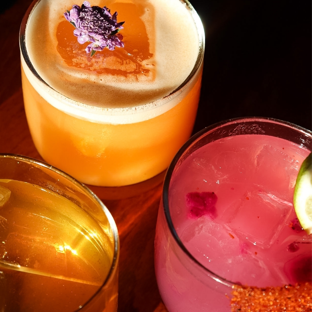Colorful craft cocktails and wine at Slowly, served during happy hour with shared bites in Pacific Beach